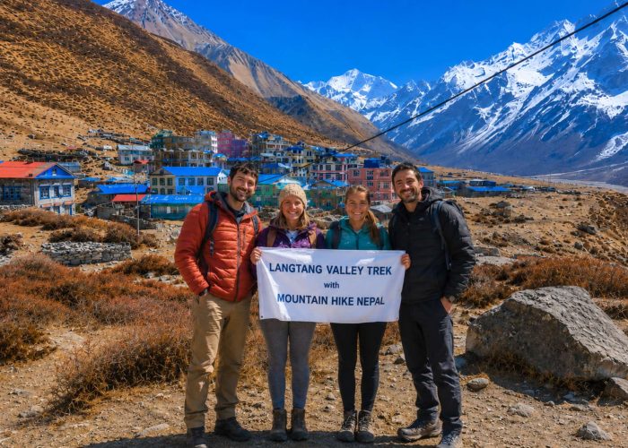 Trekkers holding Mountain Hike Nepal banner during Langtang Valley Trek near Kyanjin Gompa in Nepal