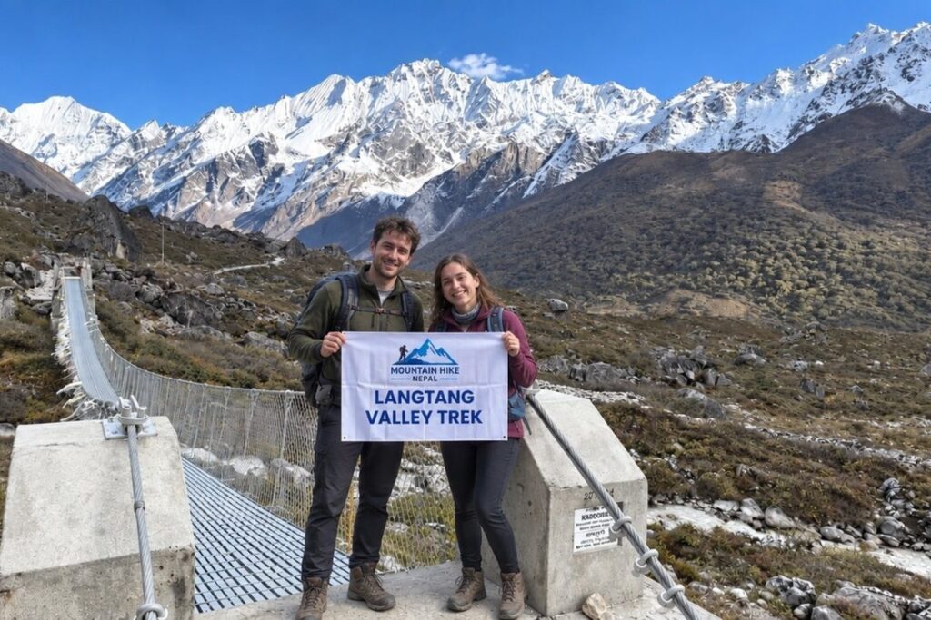 Trekkers on the Langtang Valley trail with snow-covered Himalayan mountains