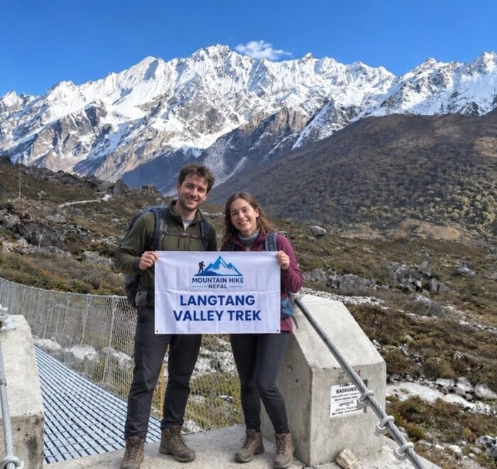 Trekkers on the Langtang Valley trail with snow-covered Himalayan mountains