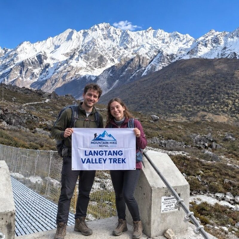 Trekkers on the Langtang Valley trail with snow-covered Himalayan mountains