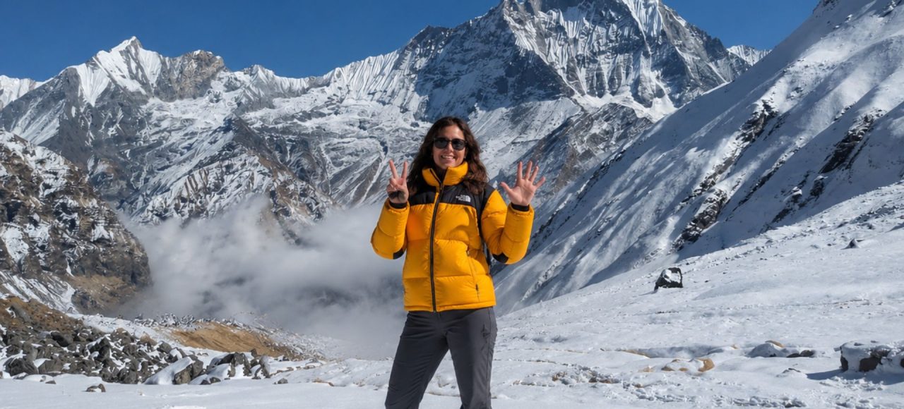 Trekker at Annapurna Base Camp with Machapuchare (Fishtail) peak and Annapurna III in the background