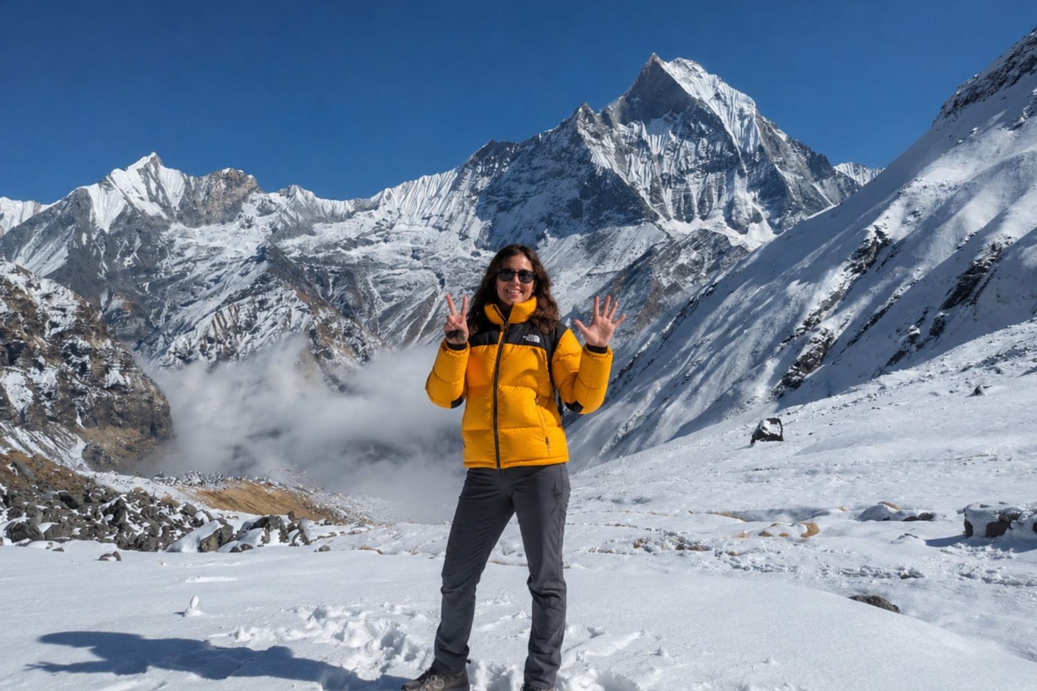 Trekker at Annapurna Base Camp with Machapuchare (Fishtail) peak and Annapurna III in the background