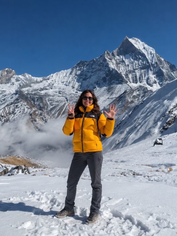 Trekker at Annapurna Base Camp with Machapuchare (Fishtail) peak and Annapurna III in the background