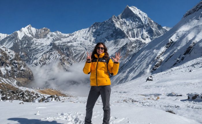 Trekker at Annapurna Base Camp with Machapuchare (Fishtail) peak and Annapurna III in the background