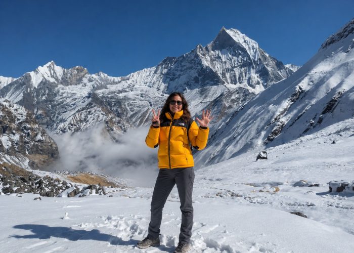 Trekker at Annapurna Base Camp with Machapuchare (Fishtail) peak and Annapurna III in the background