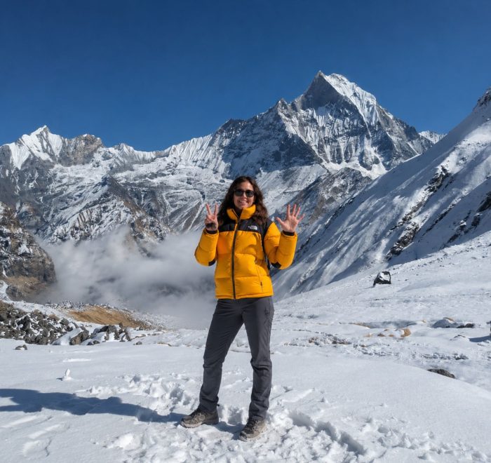Trekker at Annapurna Base Camp with Machapuchare (Fishtail) peak and Annapurna III in the background