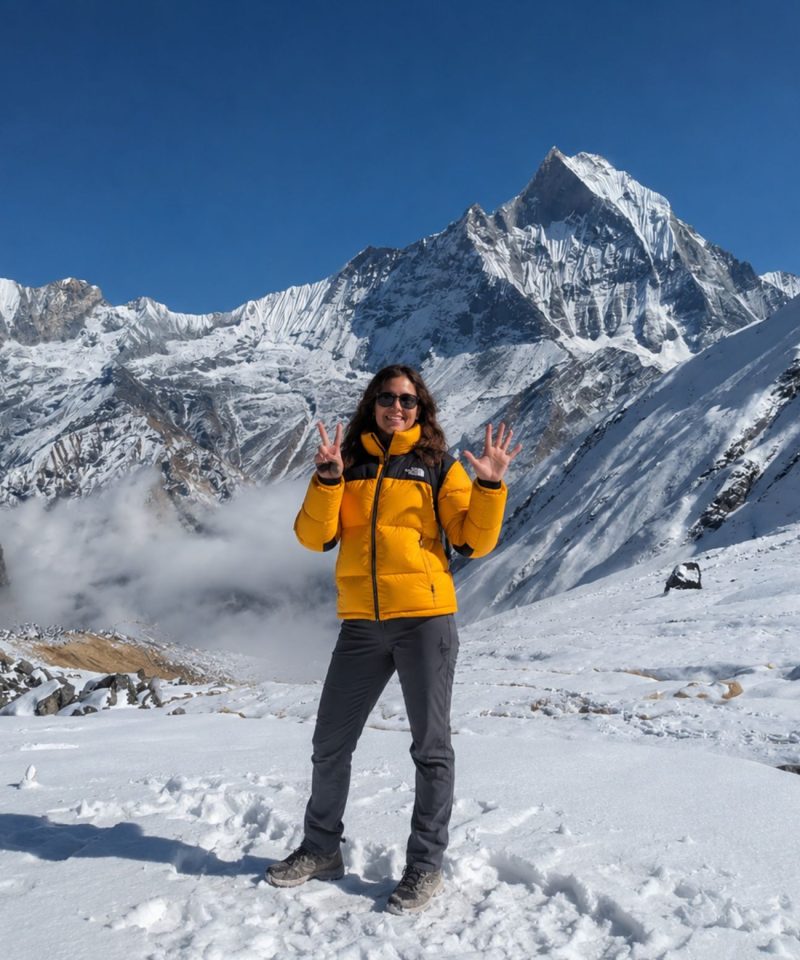 Trekker at Annapurna Base Camp with Machapuchare (Fishtail) peak and Annapurna III in the background