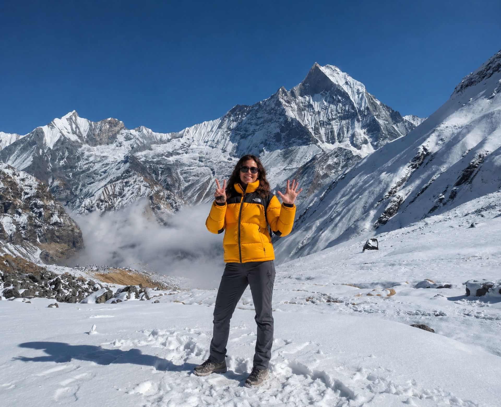 Trekker at Annapurna Base Camp with Machapuchare (Fishtail) peak and Annapurna III in the background