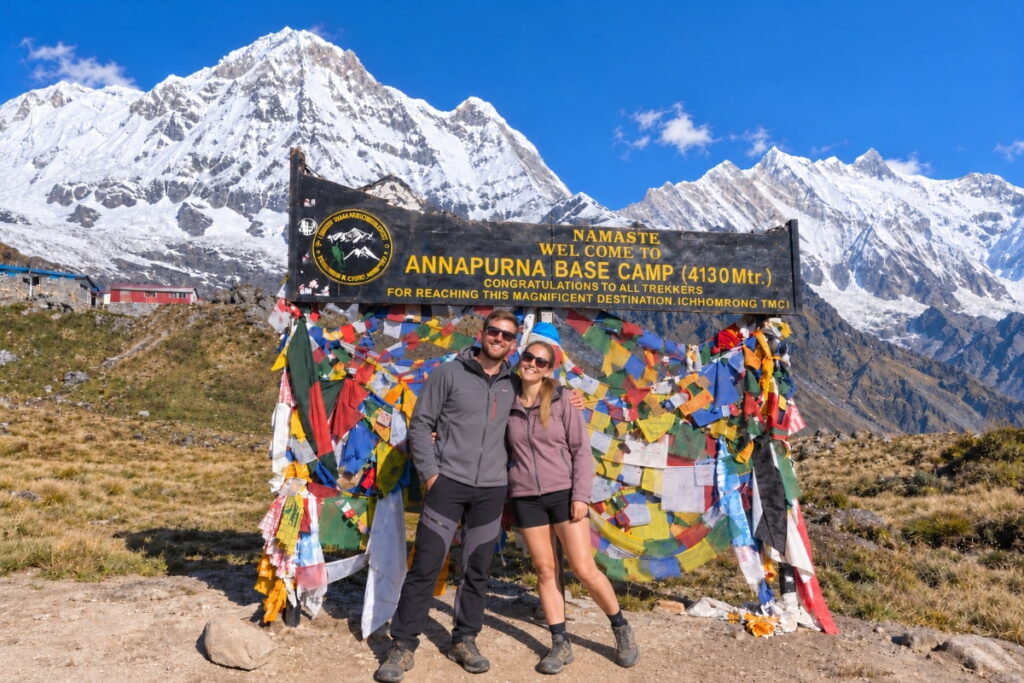 Trekkers at Annapurna Base Camp with snow-covered Himalayan mountains