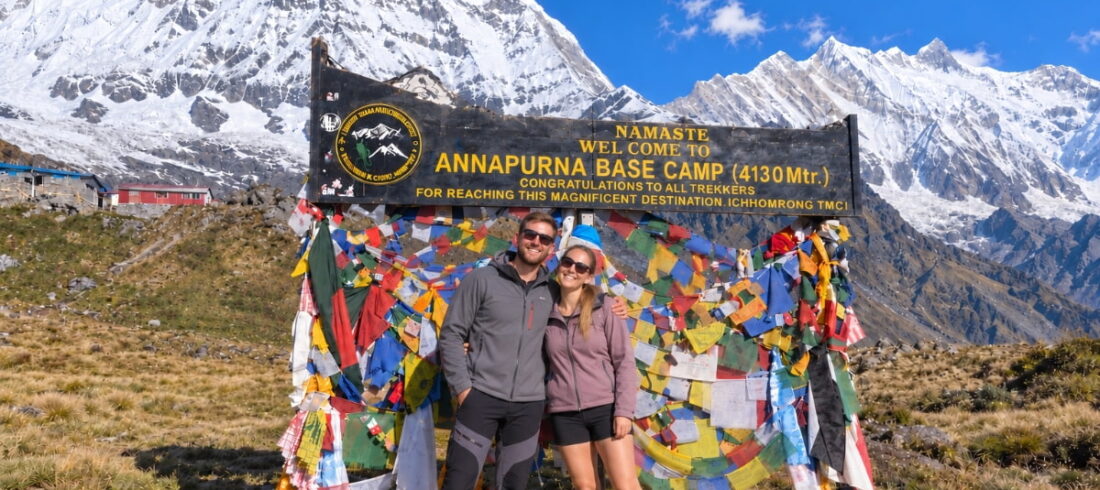 Trekkers at Annapurna Base Camp with snow-covered Himalayan mountains