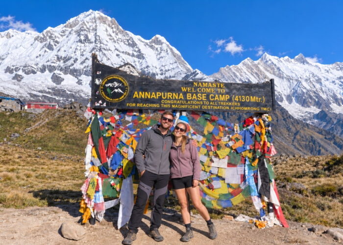 Trekkers at Annapurna Base Camp with snow-covered Himalayan mountains