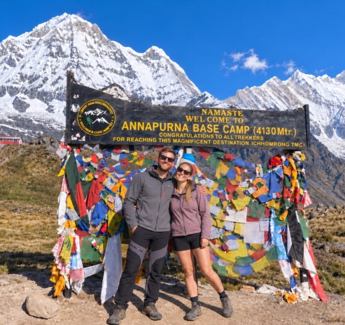 Trekkers at Annapurna Base Camp with snow-covered Himalayan mountains