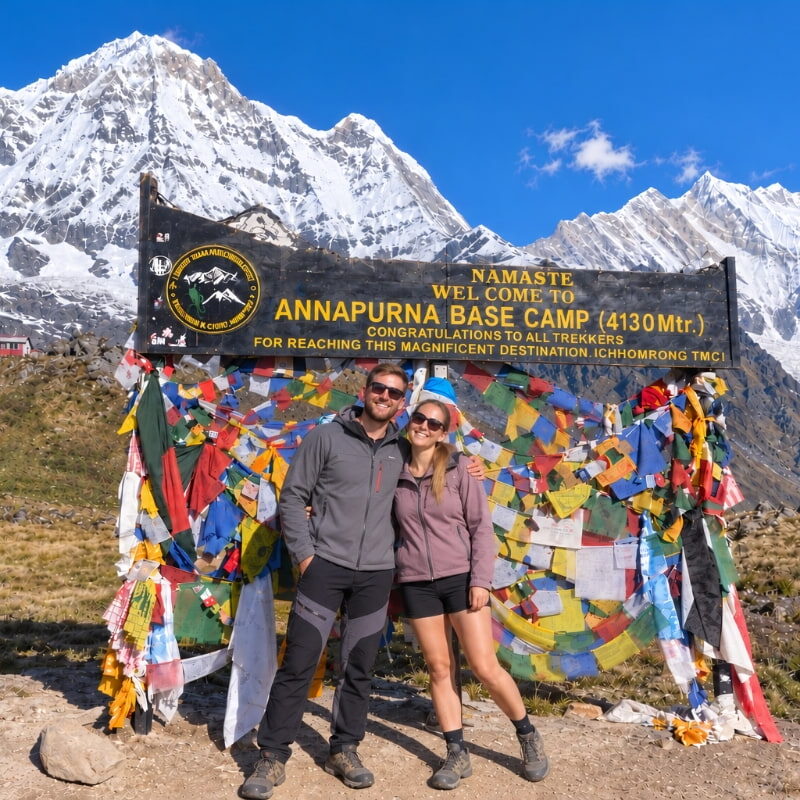 Trekkers at Annapurna Base Camp with snow-covered Himalayan mountains