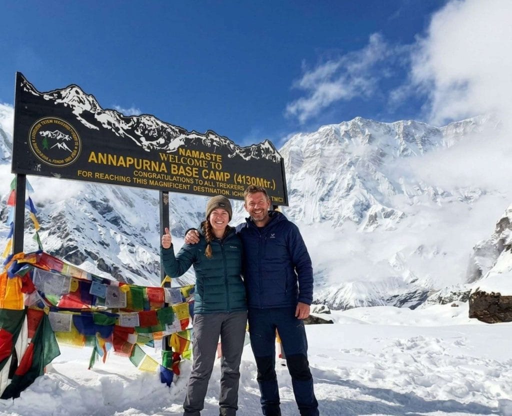 Annapurna Base Camp Trek trekkers standing at Annapurna Base Camp in snowy Himalayan landscape