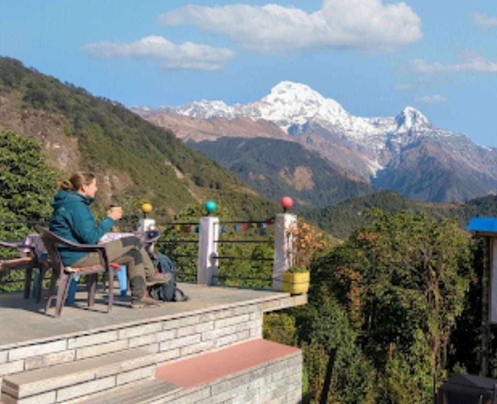 Trekker enjoying Himalayan mountain views from a teahouse during the Annapurna trek in Nepal
