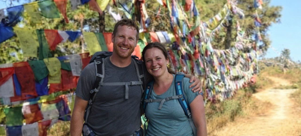 Hikers standing beside colorful prayer flags along the Champadevi Day Hike trail near Kathmandu