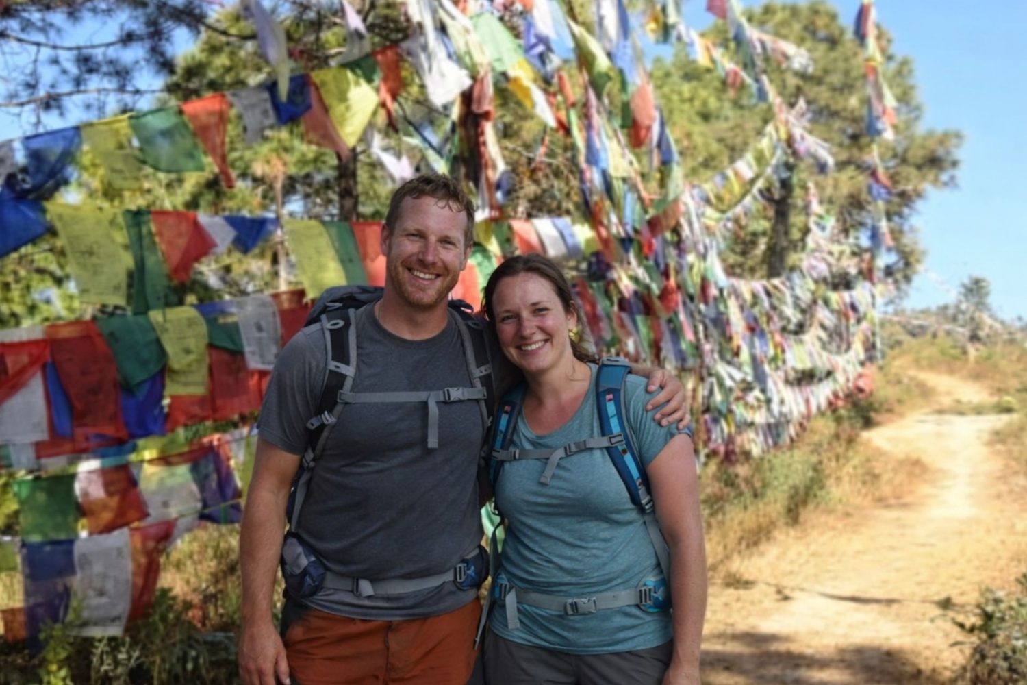 Hikers standing beside colorful prayer flags along the Champadevi Day Hike trail near Kathmandu