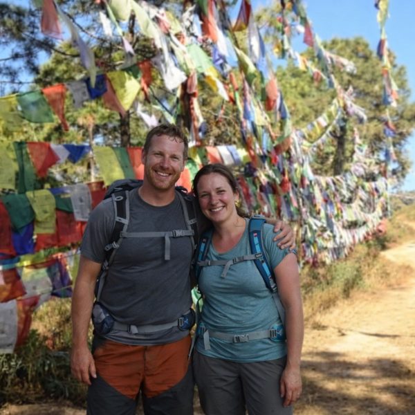 Hikers standing beside colorful prayer flags along the Champadevi Day Hike trail near Kathmandu