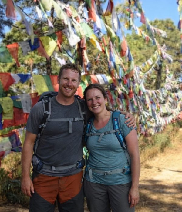 Hikers standing beside colorful prayer flags along the Champadevi Day Hike trail near Kathmandu