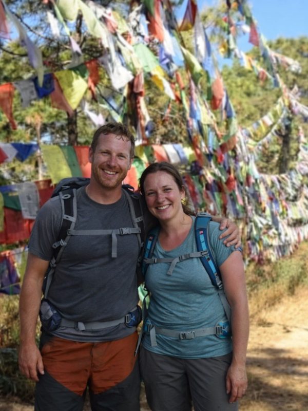 Hikers standing beside colorful prayer flags along the Champadevi Day Hike trail near Kathmandu