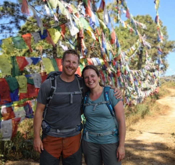 Hikers standing beside colorful prayer flags along the Champadevi Day Hike trail near Kathmandu