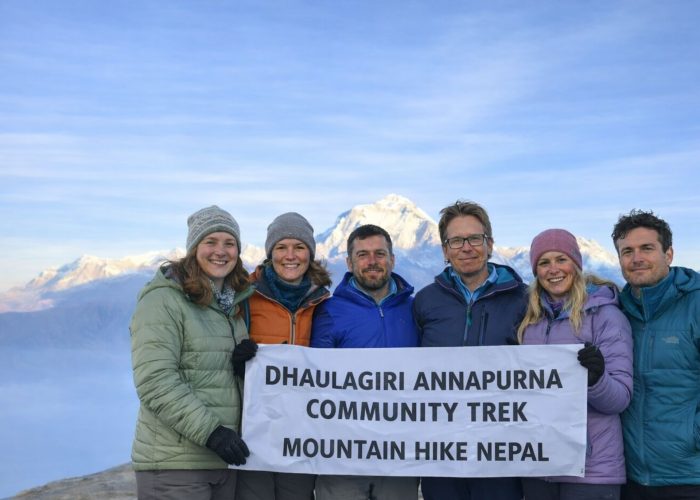Trekkers holding a banner during the Dhaulagiri–Annapurna Community Trek in Nepal