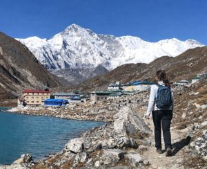 Walking trail beside Gokyo Lake Hiker walking beside turquoise Gokyo Lake with Himalayan mountains in the background