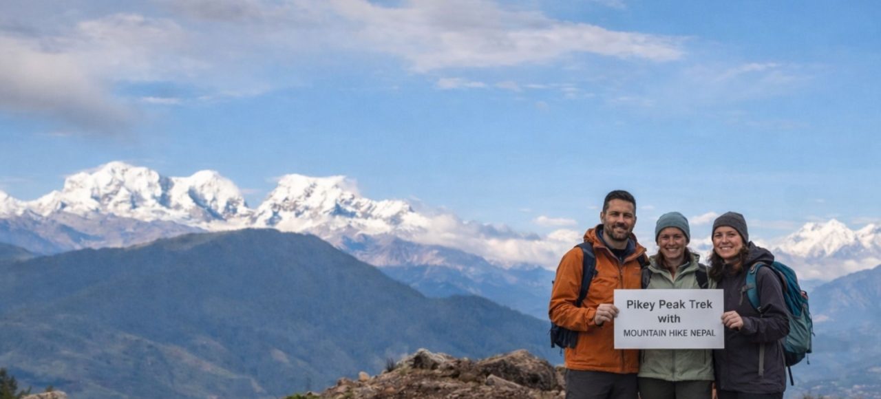 Trekkers standing at Pikey Peak summit with wide Himalayan mountain views
