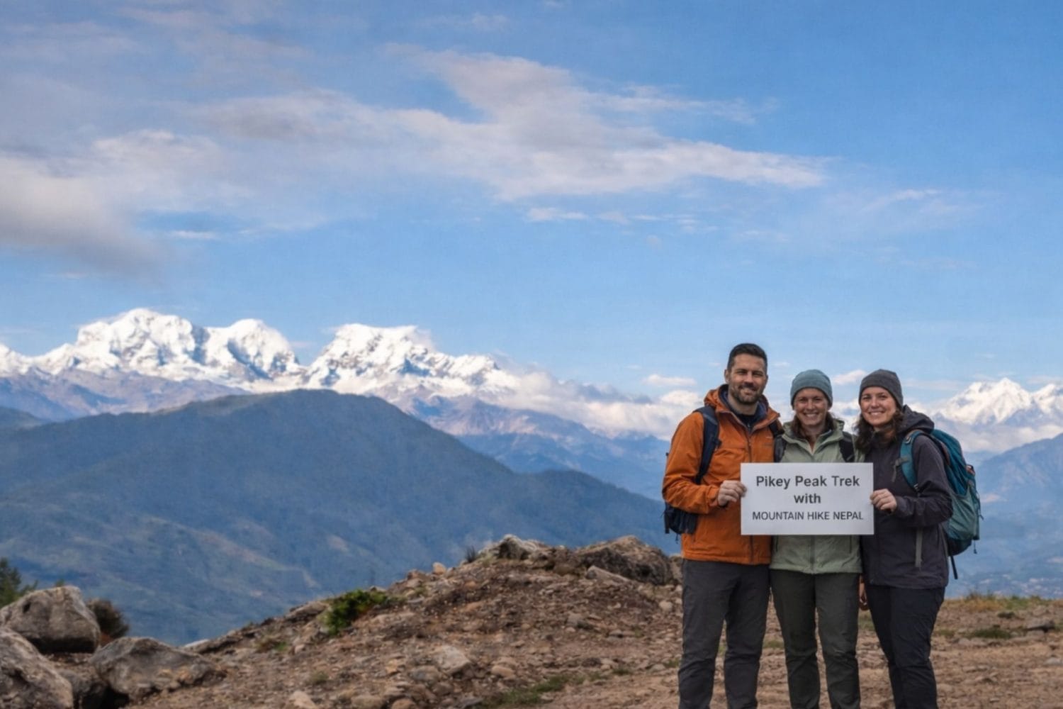 Trekkers standing at Pikey Peak summit with wide Himalayan mountain views