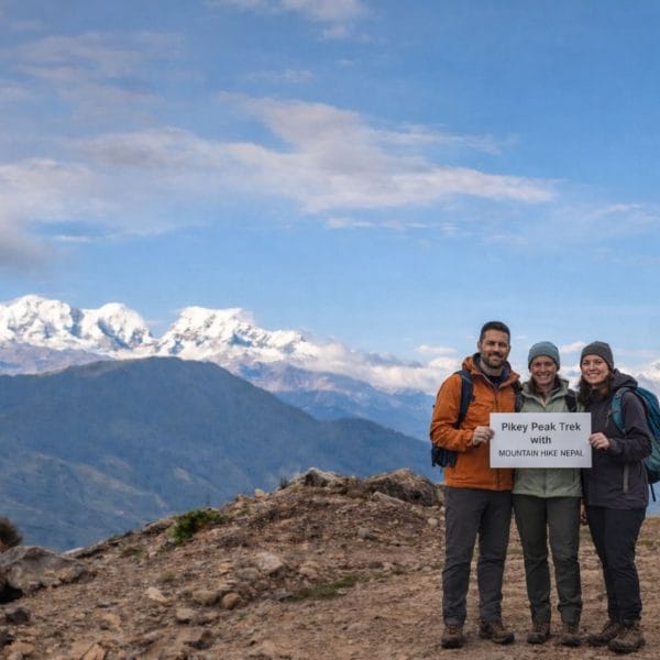 Trekkers standing at Pikey Peak summit with wide Himalayan mountain views