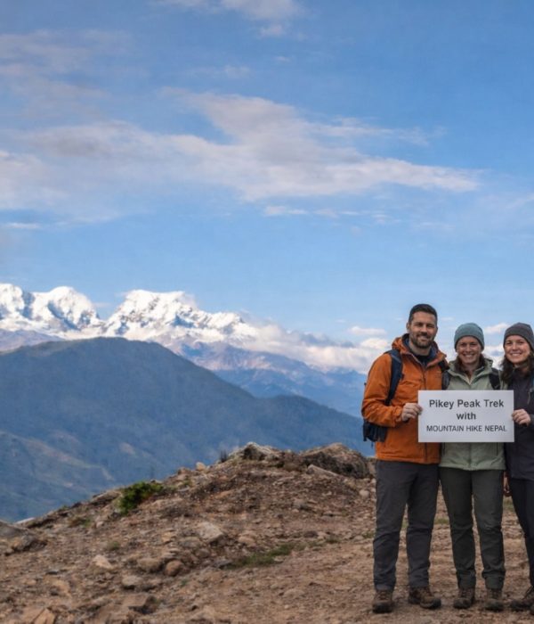 Trekkers standing at Pikey Peak summit with wide Himalayan mountain views