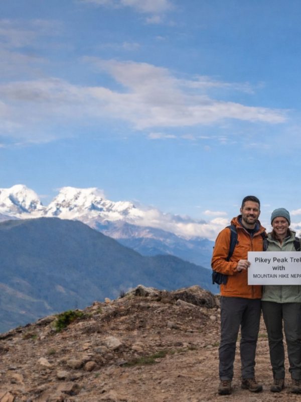 Trekkers standing at Pikey Peak summit with wide Himalayan mountain views