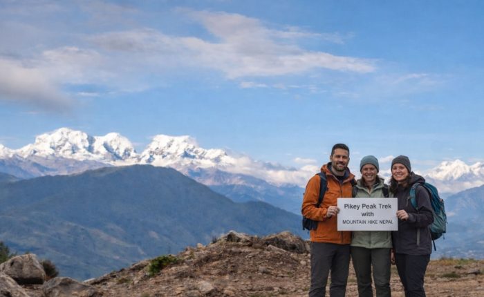 Trekkers standing at Pikey Peak summit with wide Himalayan mountain views