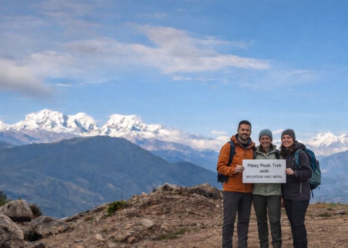 Trekkers standing at Pikey Peak summit with wide Himalayan mountain views