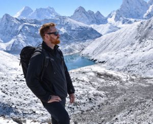 Solo trekker view in Gokyo Valley Solo trekker overlooking Gokyo Valley and glacial lake during Everest Gokyo Lakes Trek
