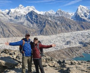 Panoramic view from Gokyo Ri Trekkers at Gokyo Ri viewpoint overlooking glaciers and Himalayan peaks