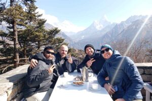 Trekkers enjoying tea on the Hotel Everest View terrace with Himalayan mountains