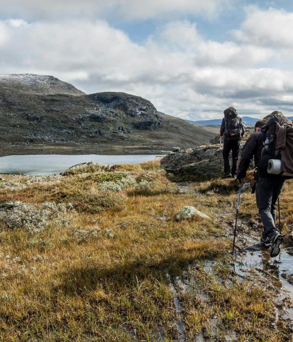 Trekkers walking beside a high mountain lake on the Langtang Helambu Circuit Trek