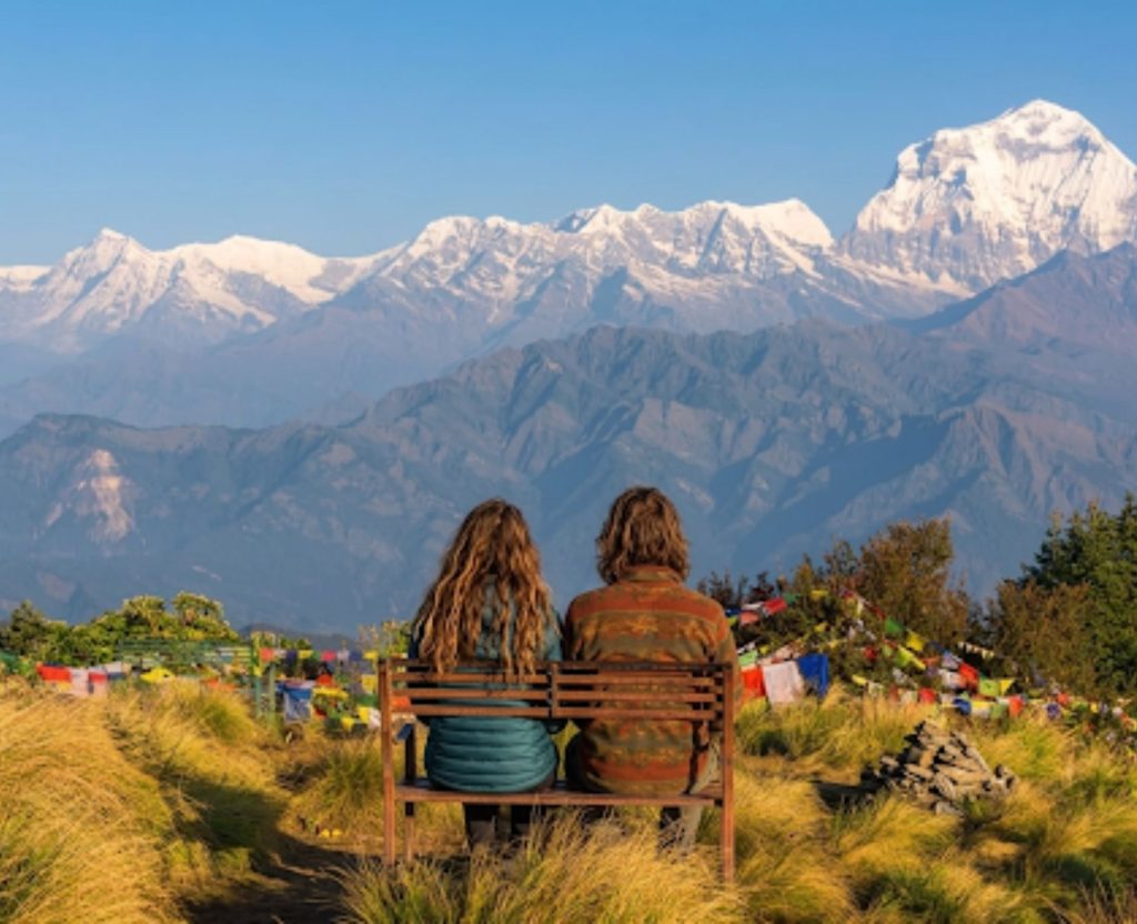 Two trekkers sitting on bench enjoying mountain view in Nepal