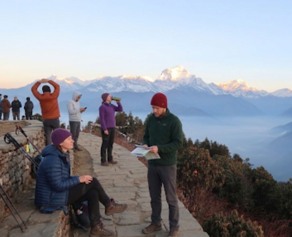 Trekkers enjoying sunrise view from Poon Hill viewpoint in Nepal