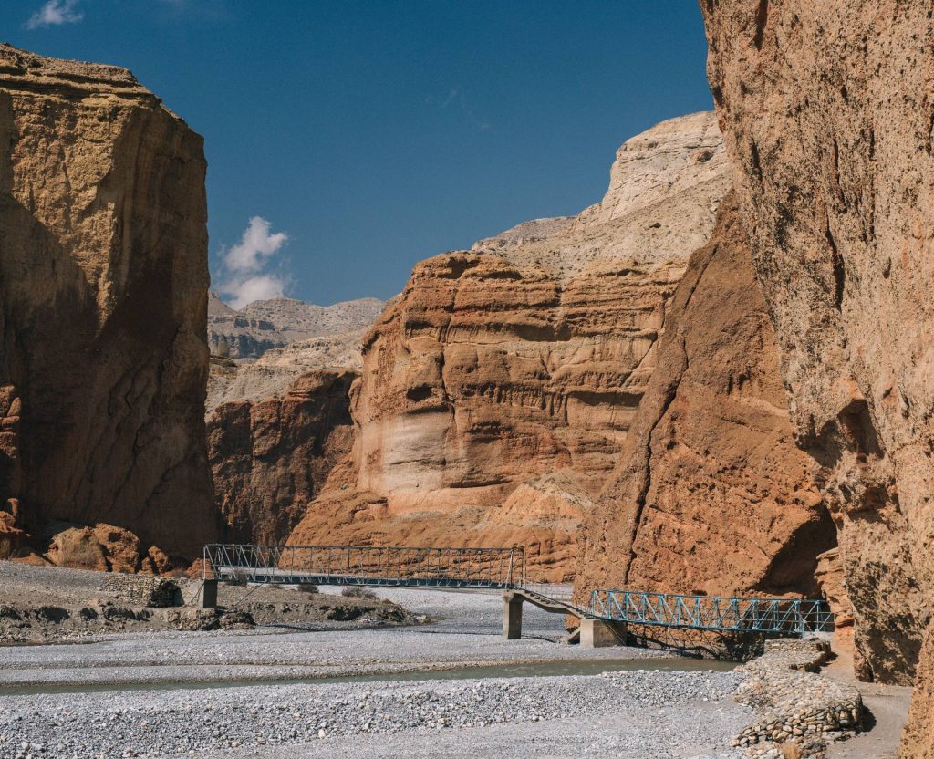 suspension bridge in Kali Gandaki valley surrounded by cliffs Mustang