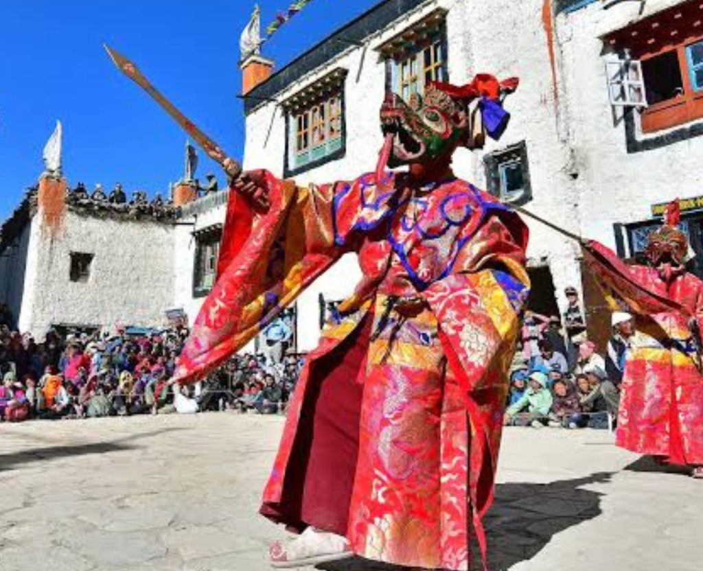 monk in red costume performing ritual dance Tiji Festival Mustang