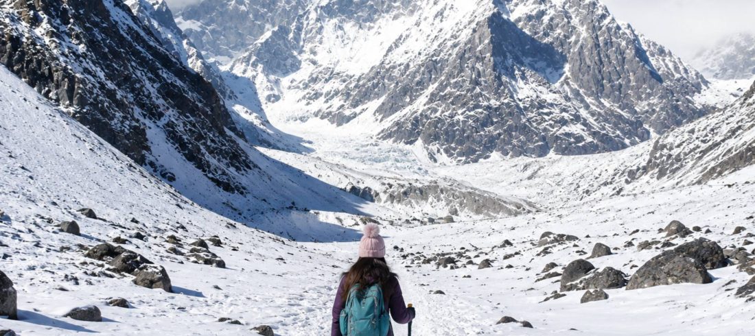 Solo trekker walking through a snowy high-altitude landscape near Annapurna Base Camp, illustrating altitude sickness risks during the trek.