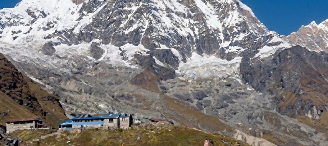Solo trekker walking toward Annapurna Base Camp with Annapurna mountain towering above, illustrating the challenge and difficulty of the Annapurna Base Camp Trek.