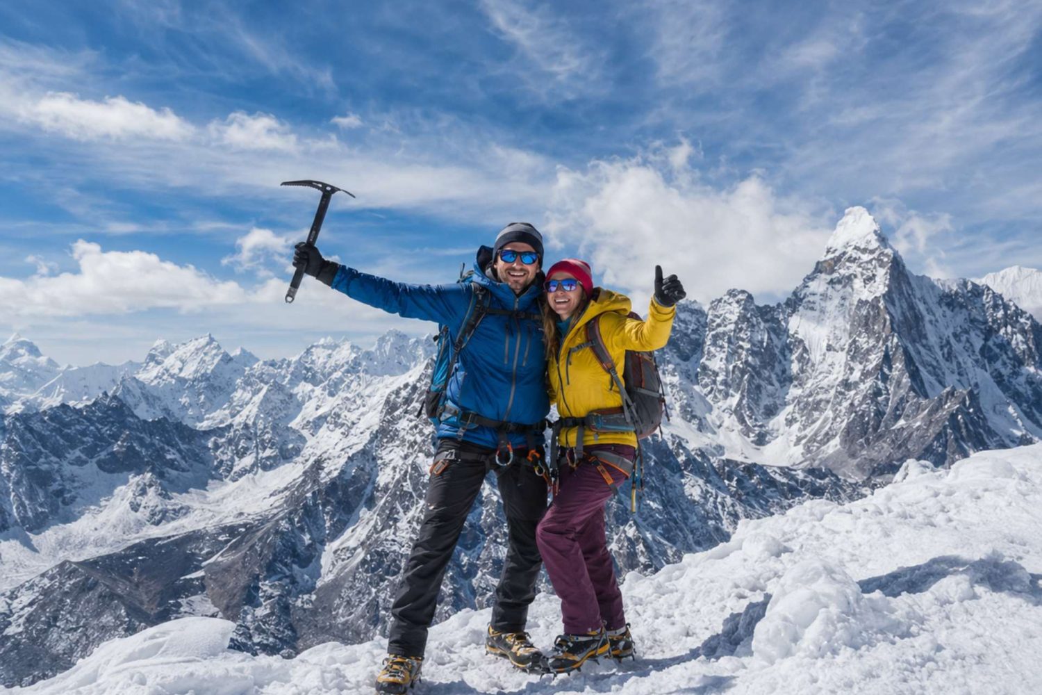 Mountaineering couple standing on a snowy Himalayan summit during Island Peak Climbing in Nepal with panoramic mountain views.