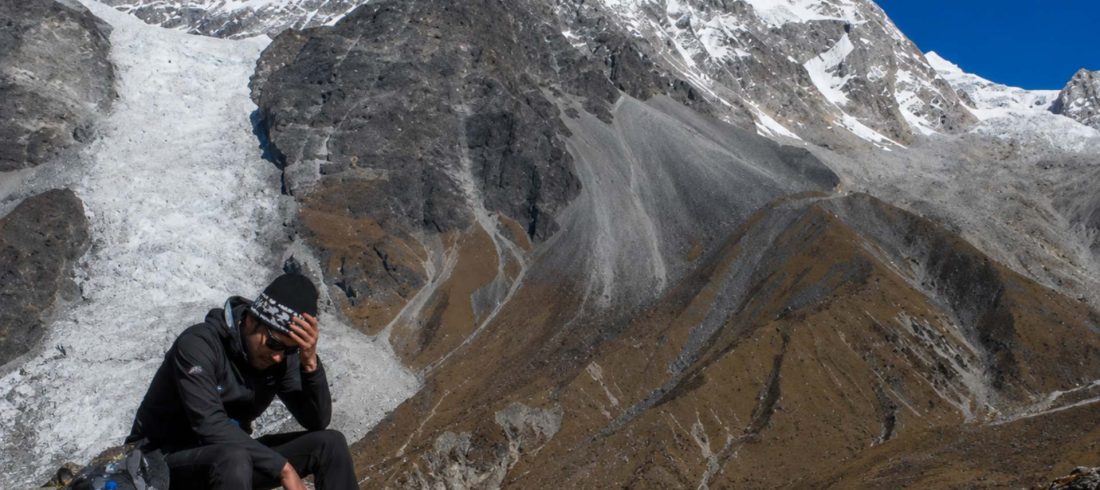 Tired trekker resting with headache symptoms at high altitude during the Langtang Valley Trek in Nepal