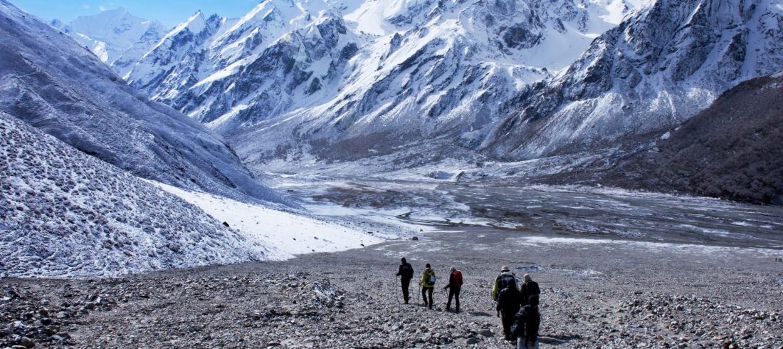 Langtang Valley trekkers walking beneath snow-covered Himalayan mountains in Nepal