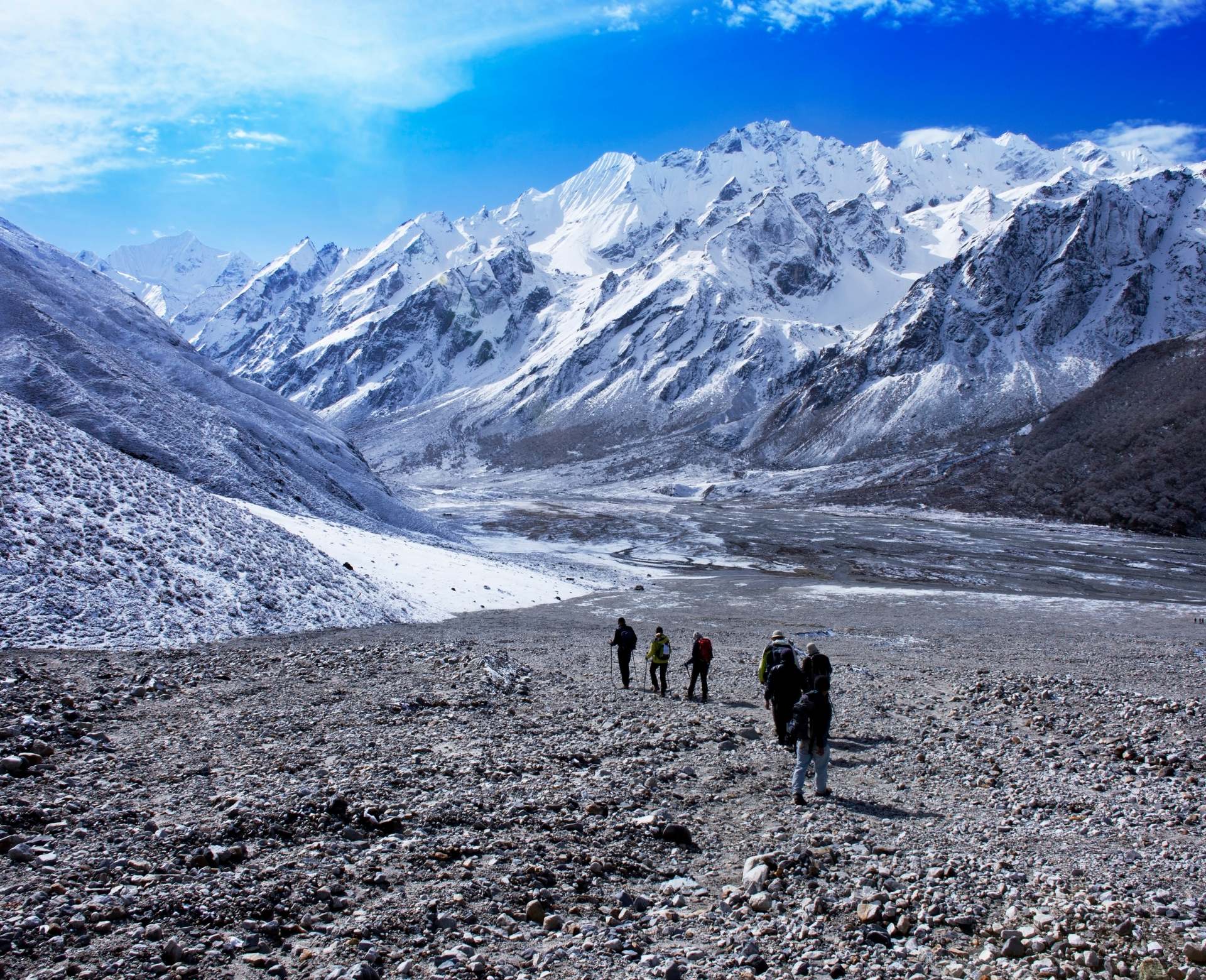 Langtang Valley trekkers walking beneath snow-covered Himalayan mountains in Nepal