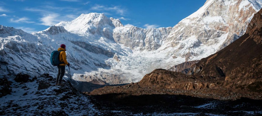Manaslu circuit trek difficulty with female trekker standing near snowy Himalayan mountains in Nepal