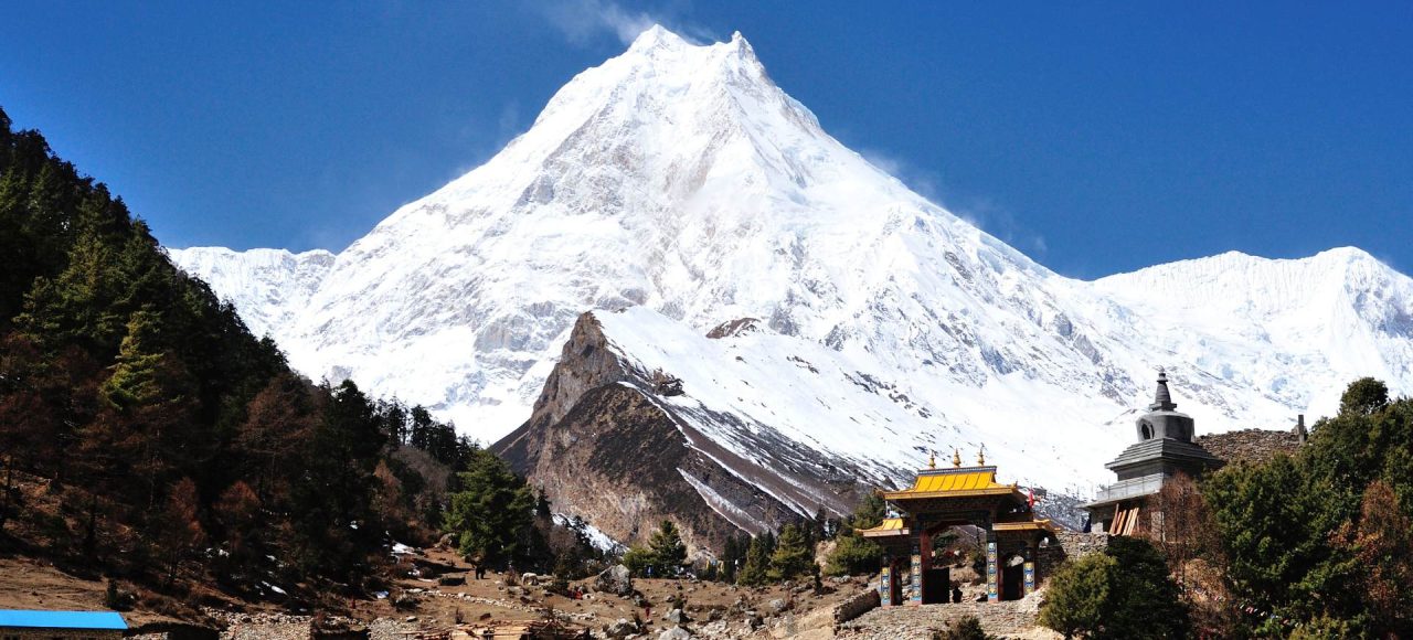 Manaslu Circuit Trek trail with Mount Manaslu and traditional gateway in Nepal